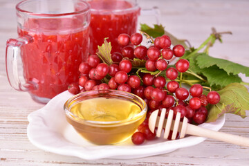 Medicinal tea or fruit drink from viburnum berries with honey on a white background.
