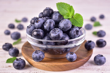 Fresh blueberries in a glass bowl on a white background.Close-up.