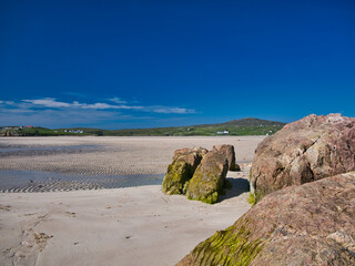 Fototapeta na wymiar A view across the deserted Ardroil Sands (Uig Sands) on the Isle of Lewis in the Outer Hebrides, Scotland, UK. Taken with a clear blue sky on a sunny day in summer.