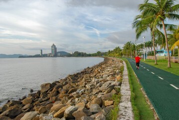 An embankment of Kota Kinabalu with a view of Kinabalu Tower, also known as Sabah State...