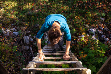 Adult woman climb up a wooden ladder - 646064595