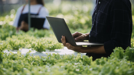 In the Industrial Greenhouse Two Agricultural Engineers Test Plants Health and Analyze Data with Tablet Computer.