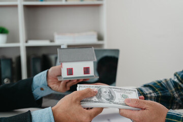 A real estate agent is talking with a client about buying a home or getting home insurance. Real estate agent buys, sells a house, agrees to buy a house.