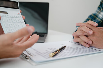 A real estate agent is talking with a client about buying a home or getting home insurance. Real estate agent buys, sells a house, agrees to buy a house.