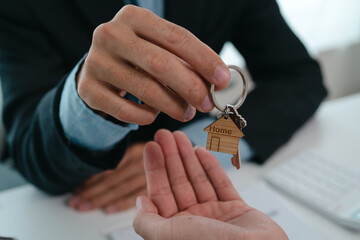 A real estate agent is talking with a client about buying a home or getting home insurance. Real estate agent buys, sells a house, agrees to buy a house.