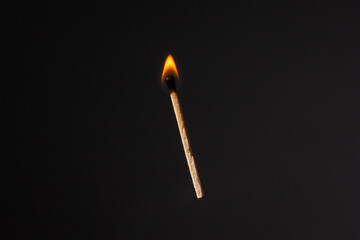 Lit falling match on a black background.