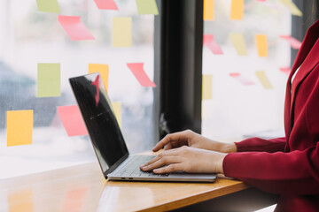 Fototapeta premium Asian Businesswoman Using laptop computer and working at office with calculator document on desk, doing planning analyzing the financial report, business plan investment, finance analysis concept.