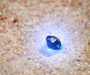 sapphire crystal in the sand.