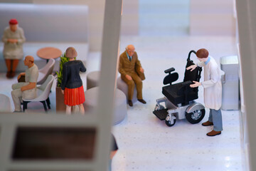 People in the lobby of the clinic with a wheelchair for the patient