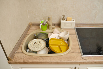 Sink in the kitchen with dirty dishes. Cluttered home room in the house