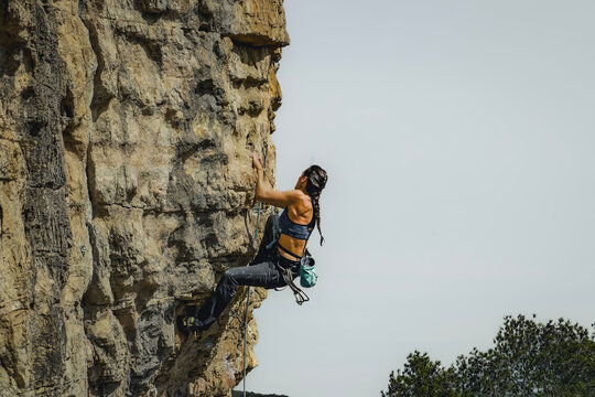 Intrepid Black-Haired Woman Rock Climbing Outdoors © Patrick