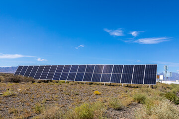 Solar panels in a rocky desert against a blue sky
