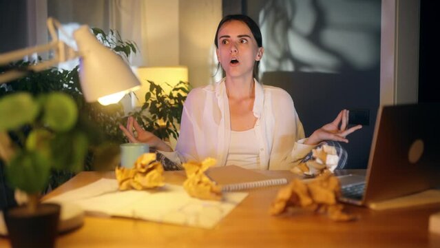 Positive young woman with failed ideas sitting in lotus pose meditating while finding solution and writing in notebook with happy inspired face at home workplace Keep calm concept