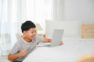 Asian male schoolboy use laptop computer study online at home happy students with education typing on keyboard looking at pc screen Watch Webinars Online Courses Do Homework