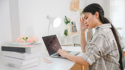 A woman overworked feeling tired headache and have eye problems After working on a laptop computer...