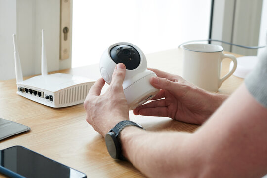 Closeup image of man installing security camera in home office