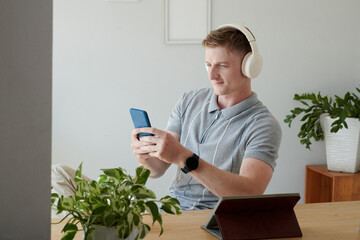 Smiling man in headphones video calling coworker