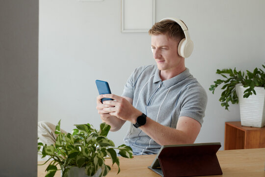 Smiling man in headphones video calling coworker