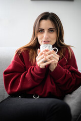 Young woman having a hot drink at home