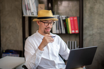 Businessman in casual clothes Focus on working in front of laptop at home office.