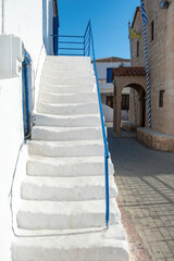 Megalochori, Milos, Miloi village Agistri island Greece. White stairway, church, sunny day. Vertical