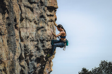 Focused Effort: Black-Haired Woman Climbing a Wall