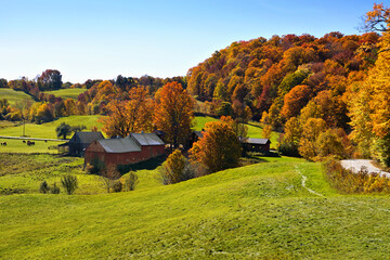 Fototapeta premium Autumn countryside with rustic red wooden barns and colorful fall leaves near Woodstock, Vermont, USA
