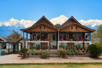 Beautiful wooden houses with Kanchenjunga Himalaya mountain range in the background at Tinchuley, Darjeeling, India.