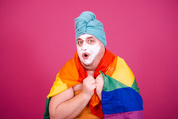 Early morning. Funny fat man after a shower getting ready for a party. Pink background.