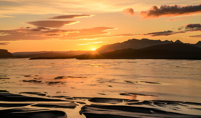 First ray of sun on a braided glacial river and mountain range in Iceland's  Highlands, Sudurland, Iceland