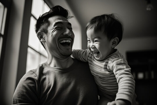 a black and white picture of a dad and his son enjoying and laughing 