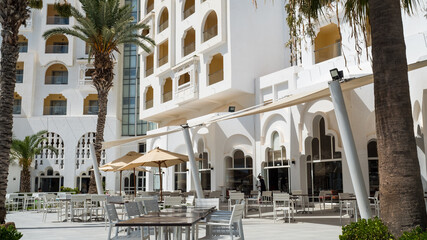 Facade of an arab style luxury hotel with palms trees.
