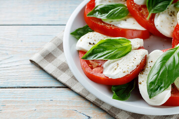 Plate of Healthy Classic Caprese Salad with Mozzarella Cheese, Tomatoes and Basil. Caprese Salad on Wooden Boards. Copy Space