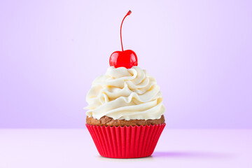 Cupcake. Birthday cupcake with cherry on top. Red cup liners. Happy Birthday. Tasty baking cupcakes, cake or muffin with white cream icing, frosting. Bakery, confectionery. Purple background.