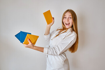 A woman holds a paper yellow and blue envelope in her hand. New mail, message. Postal service. A...