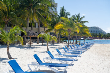 Row of sunbeds on sandy beach. Cancun resorts