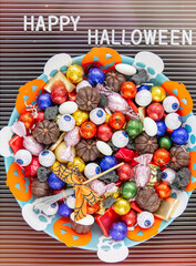 Fototapeta na wymiar decorated holiday table Halloween Jack o Lantern candy bowl with sweets and halloween cookies Trick or Treat dark background