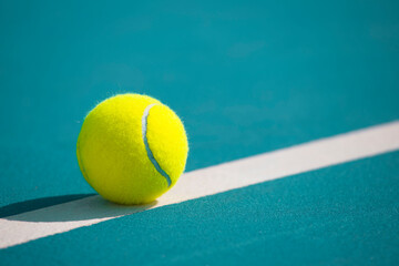 Tennis ball on the blue-coated court