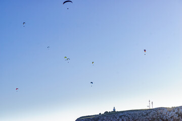 Fototapeta na wymiar Paragliders flying in sky.