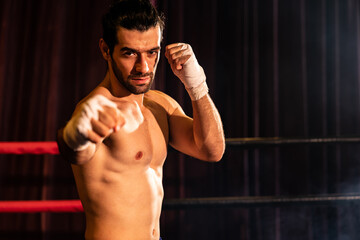 Boxing fighter shirtless posing, caucasian boxer punch his bare fist and wrap in front of camera,...