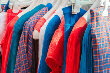 Fashion clothes on clothing rack  Closeup of rainbow color choice female wear on hangers in store...