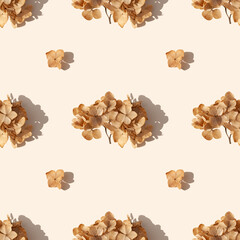 Dried hydrangea flower on a beige background with a shadow. Seamless pattern, autumn season minimal wallpaper concept