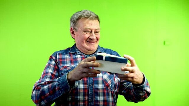 Senior caucasian man looks at useless gift and throws it in disappointment.