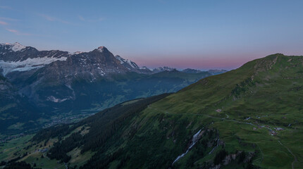 View on the Eiger Nordwand and other famous Swiss Alpine mountains during sunrise on a summer morning, as seen from the mountain hut First on First mountain. early morning sunrise in Switzerland.