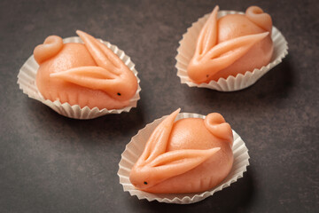 Portuguese marzipan delicacy in the shape of pink hare a rabbit. Gourmet sweets from the Algarve Portugal on a marble background close-up.