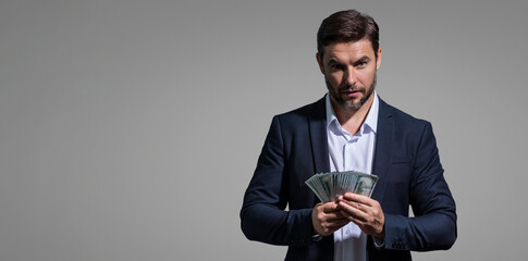 Good payment. Handsome man holding money isolated over grey studio. Money in dollar banknotes. Pile of cash, finance, investment and money saving. Mockup banner.