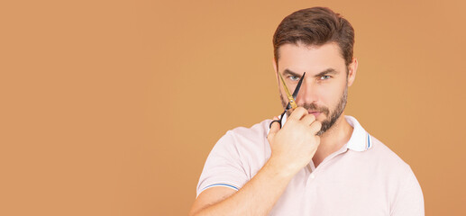 Banner of men hairstyle, haircut. Guy with scissors. Mens haircare, beauty barber concept. Portrait of unshaven man, with scissors. Man cut hair with scissors. Hair styling and cut with scissors.