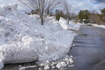 large plowed pile of snow at the side of street after blizzard in New England