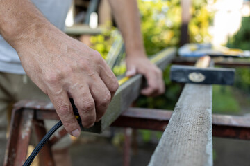 Mans hands preparing wood for processing 