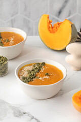 Plates with pumpkin soup puree, pumpkin and sesame seeds. Autumn menu. 